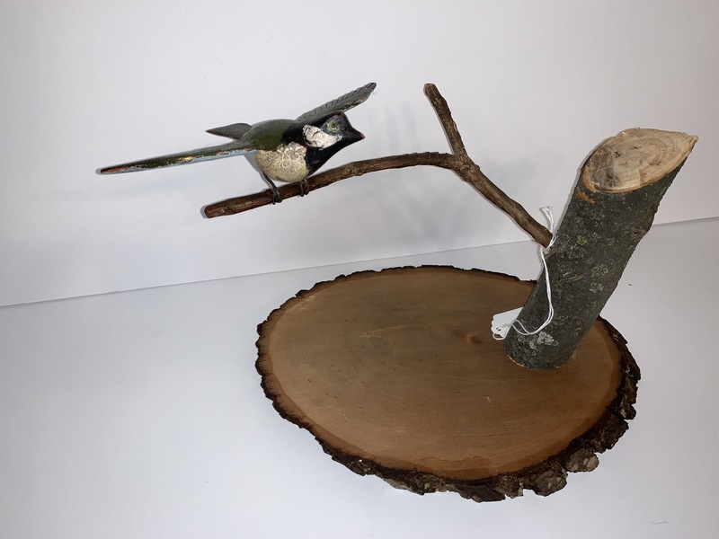 Folk Art carved bird on a branch.