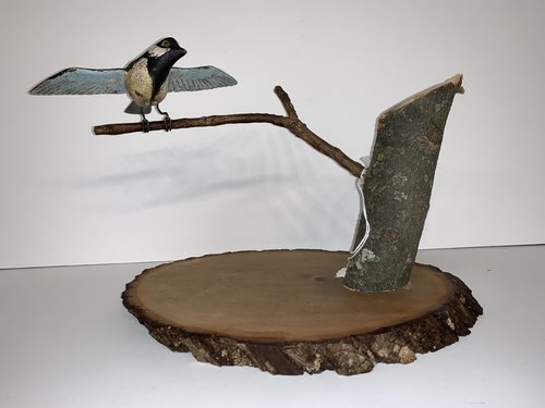 Folk Art carved bird on a branch.